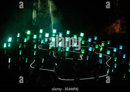A mesmerizing outdoor light art installation photographed at night, featuring numerous cylindrical light fixtures arranged in geometric patterns Stock Photo