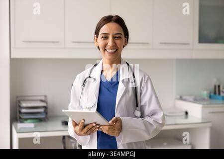 Portrait smiling female cardiologist doctor holding tablet Stock Photo