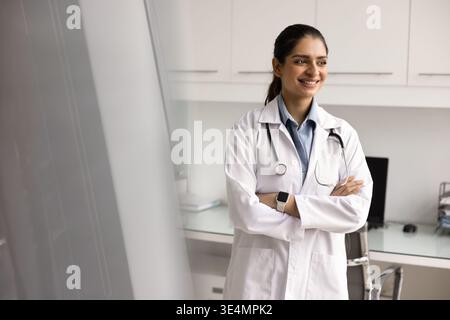 Indian doctor in white coat stand in modern examination room Stock Photo