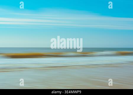 Blurred motion of ocean waves creates an abstract seascape with soft horizontal lines and colors. Stock Photo