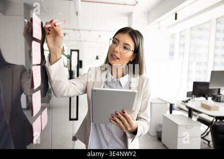 Confident young businesswoman engaged in planning or team coordination Stock Photo