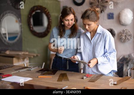 Artisans collaborating on glasswork project in workshop studio Stock Photo