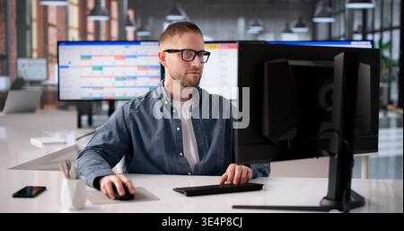 Young Software Developer Strategizes Agile Project Timeline On Computer Using Gantt Chart Stock Photo