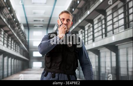 Correctional Officer Patrols Prison Hallway, Communicating Rapidly Via Walkie-Talkie Stock Photo
