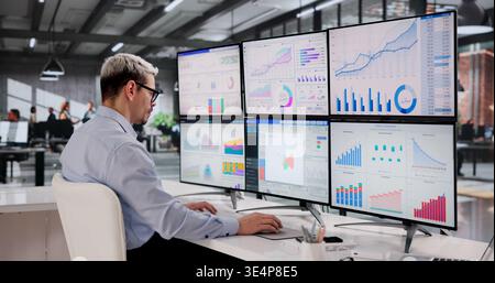 Latinx Business Analyst Analyzing Financial And Market KPIs On Office Monitor Stock Photo