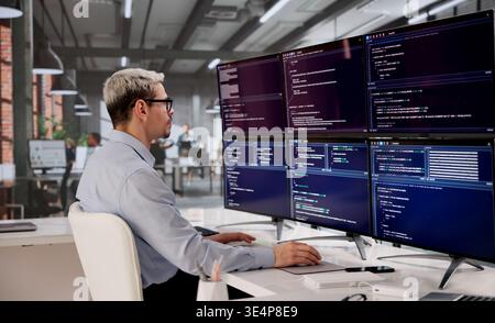 Hispanic Software Engineer Writing Code For Modern Web Apps On Desktop Monitor Stock Photo