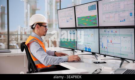 Engineer Oversees Automated Computer System Managing Energy Operations At Gas And Oil Facility Stock Photo