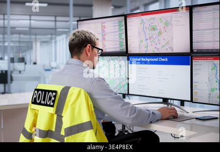 Police Officer Calmly Conducting Background Inquiry At Desk In Modern Office Stock Photo
