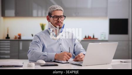 Injured Worker Documenting Accident Report On Laptop In Workplace Safety Setting Stock Photo
