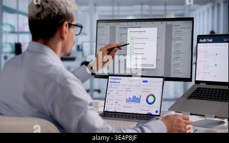 Hispanic Man Reviewing And Approving Digital Checklist Using Cloud-Based Workflow Software At Laptop Stock Photo