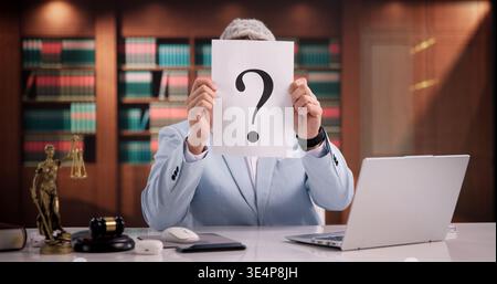 Confused Male Lawyer Holding Paper With Question Mark In Office Setting Stock Photo