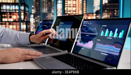 Focused Data Analyst Reviews Business Metrics On Laptop, Motivated For Success Stock Photo