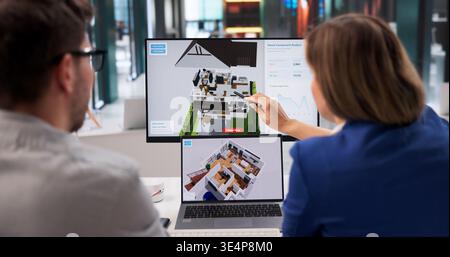 Architect Examines 3D Home Model On Laptop For Renovation Planning Stock Photo