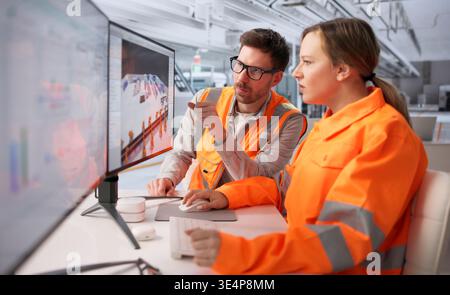 Engineers Collaborating On 3D CAD Software To Enhance Industrial Plant Layout Stock Photo