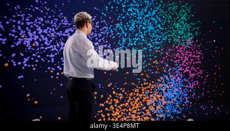 Hispanic Man Exploring Big Data Clustering Techniques On An Interactive Display Stock Photo