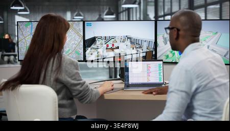 Young Man And Woman Using Computer Software For BIM 3D Model Design. Engineers And Architects Reviewing Virtual Models Stock Photo