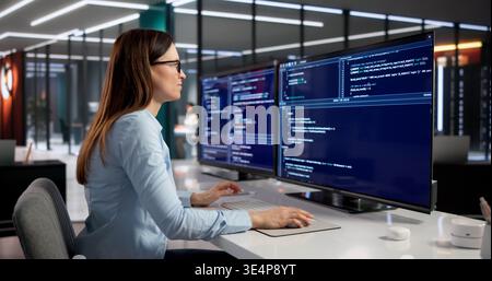 Female Software Engineer Deeply Engaged In Coding On Desktop Computer Stock Photo