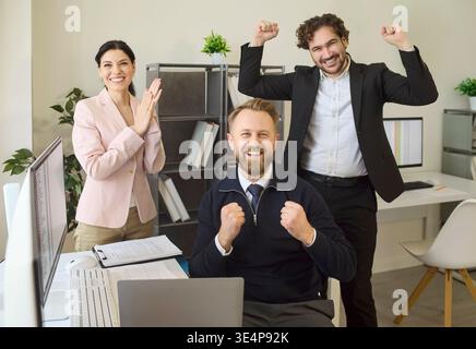 Happy business team celebrating office success after achieving goals winning deal Stock Photo