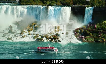 A ship with tourists sails under the famous Niagara Falls. View from the Canadian coast Stock Photo