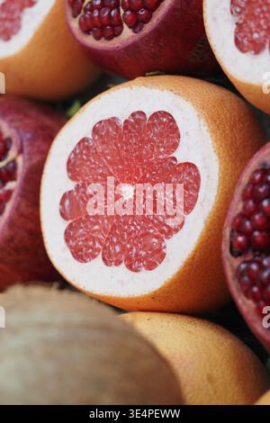 Cut grapefruit with red seeds displayed on a table Stock Photo