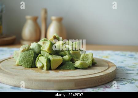 Freshly cut avocados on a wooden board in the kitchen Stock Photo