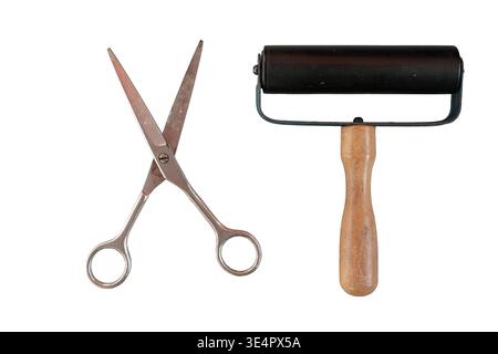 Rubber roller and metal scissors isolated on white background. Collage elements, scrapbooking, and creative paper cut compositions. Stock Photo