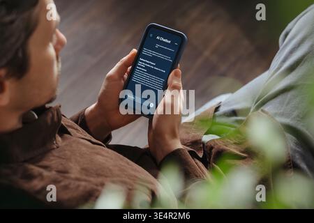 Close up of a man holding a smartphone, using an AI chatbot app for work, brainstorm a business project. Personal Artificial intelligence assistant helping with productivity. Space for text Stock Photo