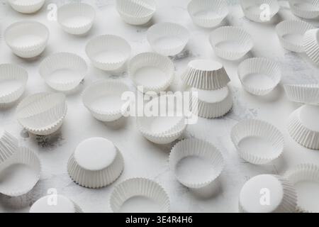 Paper baking molds for cupcakes or muffin on white table. Stock Photo