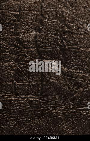 Close up, macro of detailed texture of brown glossy metallic effect leather surface with wrinkles, creases and natural grain. Textured luxury material Stock Photo