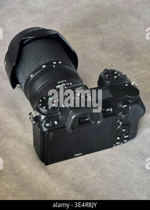 Rear view of a Nikon Z6 II mirrorless digital camera with a Nikkor 28-75mm f/2.8 lens and lens hood attached, showing control buttons and LCD screen, Stock Photo