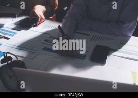 Above table with finance papers, graphs and big data during teamwork meeting with accounting or marketing team discussing budget, strategy or growth d Stock Photo