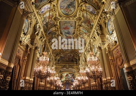 Paris,France-Oct.4th 2025: Low angle shot of the ornate ceiling frescoes and crystal chandeliers inside the Grand Foyer of the Palais Garnier Stock Photo