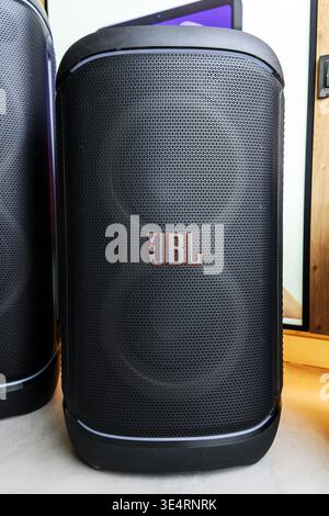 Black, portable JBL speakers with mesh grilles sit side by side on a floor Stock Photo