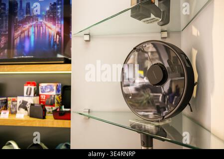 Modern Robot vacuum featuring glass shelves and a wall-mounted fan Stock Photo