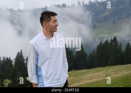 Asian man side view at misty Mount Rigi, Switzerland Stock Photo