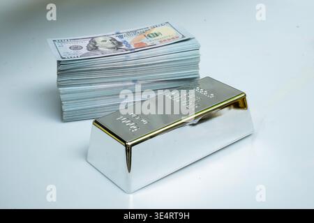 Fine silver bar and pile money banknote 100 USD on a gray background Stock Photo