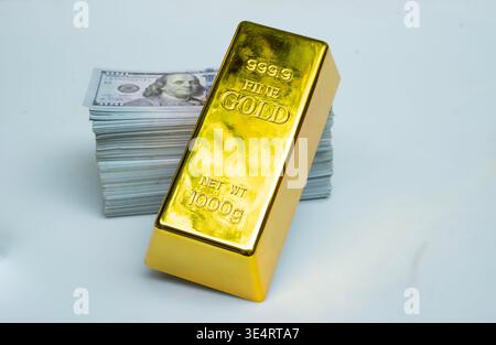 Gold bar and pile money banknote 100 USD on a gray background Stock Photo