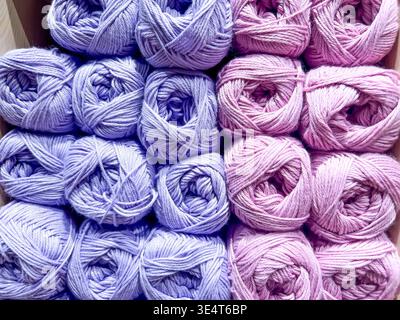 Balls of mauve and pink wool neatly arranged and on sale in a haberdashery shop Stock Photo