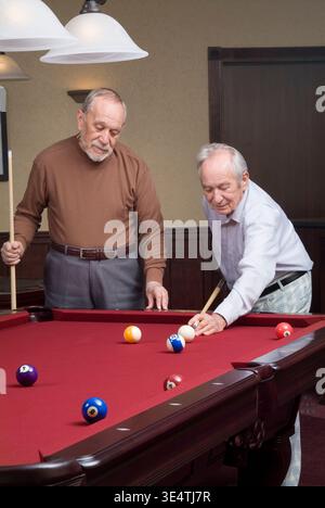 Two elderly men shooting pool billiards, Pennsylvania USA Stock Photo