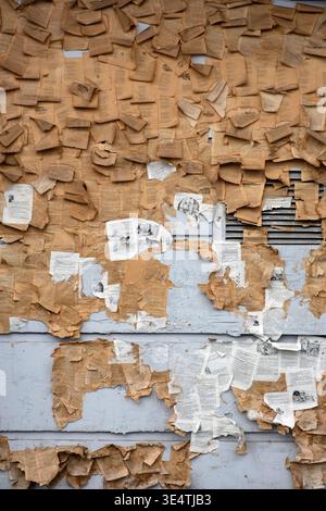 Abstract collage of vintage torn book pages on a weathered wall Stock Photo