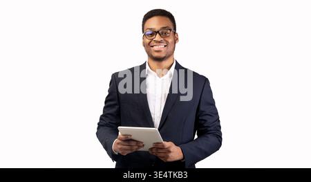 Smiling black guy standing with tablet at studio Stock Photo