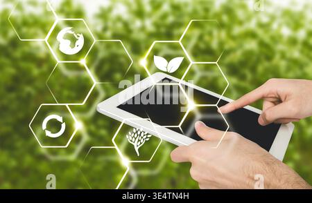 Man hand using digital tablet, virtual icons of farming Stock Photo
