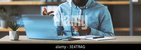 Young Black Man Teaches Online While Working From Home Office During COVID-19 Pandemic Stock Photo