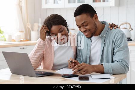 Portrait Of Happy Black Spouses Reading Insurance Documents At Home Stock Photo