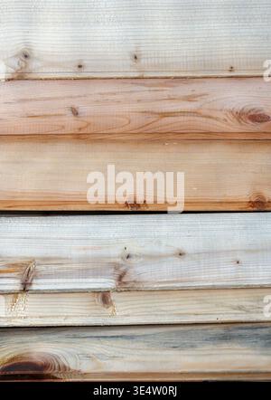 Stack of natural wooden planks with visible knots and grain. A close-up view of weathered timber boards featuring organic textures and varying shades Stock Photo
