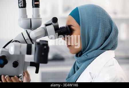 Muslim woman dentist using microscope for treatment Stock Photo