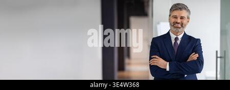 Handsome Middle Aged Businessman In Suit Standing With Folded Arms Stock Photo