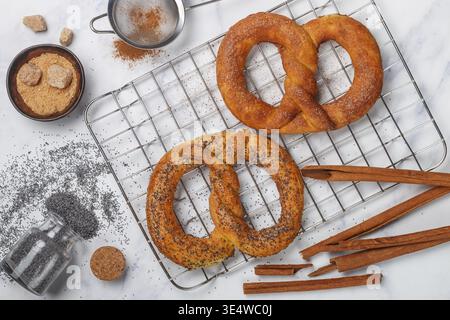 Food, Pretzel. Freshly baked pretzels with sugar, poppy seeds and cinnamon. Delicious homemade cakes and ingredients on the table. Selective focus, to Stock Photo