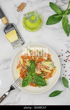Food, Tricolor pasta. Multicolored Penne (wheat, spinach, tomato) in a white plate with cheese, Basil and olive oil. Delicious Mediterranean dinner. S Stock Photo