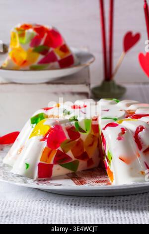 A cream cake with jelly pieces of different colors on a light background. Valentine's Day dessert. Stock Photo